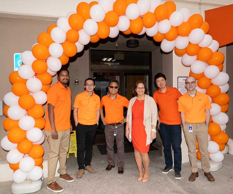 public storage employees stand under orange balloon arch